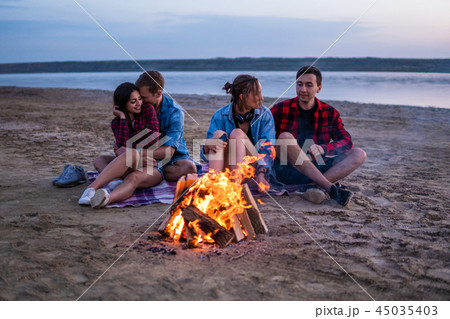 young friends have picnic with bonfire on the beach young friends have picnic with bonfire on the beach 45035403