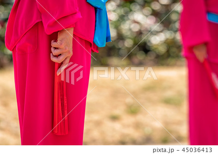 Woman holding red fan during Tai Chi exercises Woman holding red fan during Tai Chi exercises 45036413