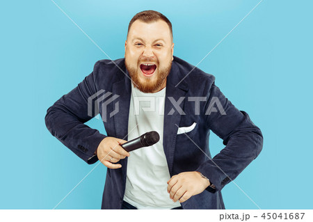 Young man with microphone on blue background, leading concept 45041687