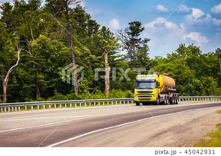 Yellow truck with tank semi-trailer on a road 45042931