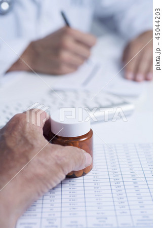 doctor prescribing pills to a senior man 45044203