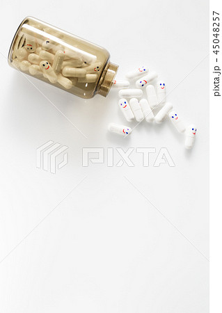 Glass bottle with fun painted emotions on the capsules. View from above. Glass bottle with fun painted emotions on the capsules. View from above. 45048257