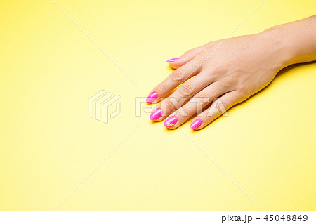 Stylish manicure pink on a yellow background Stylish manicure pink on a yellow background 45048849