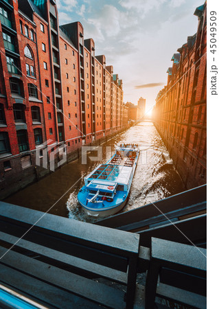 Touristic cruise boat in narrow canal of famous Speicherstadt warehouse district with red brick 45049509