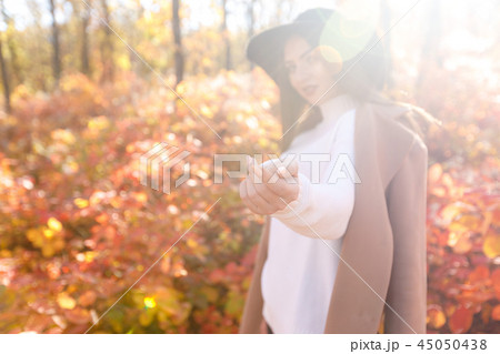 woman smiling and inviting to follow her in autumn park. woman smiling and inviting to follow her in autumn park. 45050438