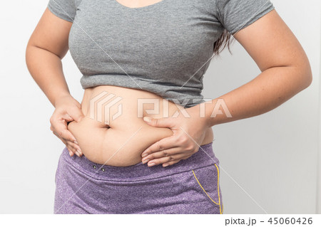 Overweight woman hand pinching excessive belly fat 45060426