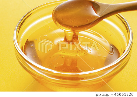 ハチミツをスプーンで掬うの写真素材