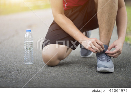 Man knee down with tie sneakers shoestring, Runner Man knee down with tie sneakers shoestring, Runner 45064975