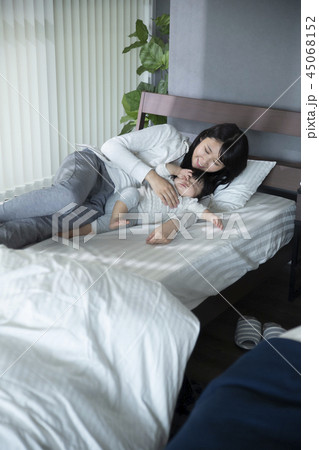ベッドでゴロゴロする母子 45068152
