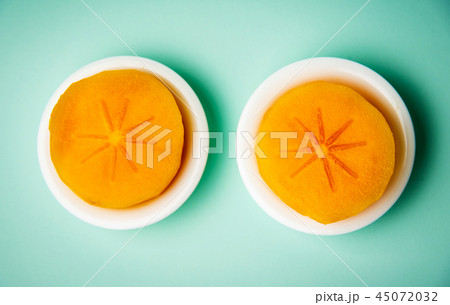 Persimmon kaki fruit on a plate top view 45072032