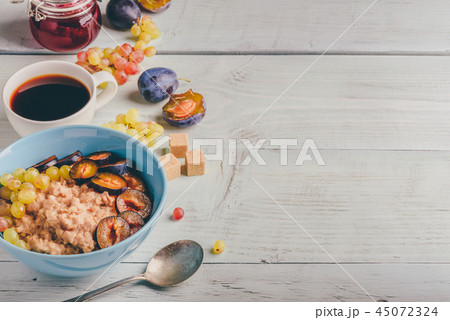 Porridge with plum, grapes and cup of coffee Porridge with plum, grapes and cup of coffee 45072324