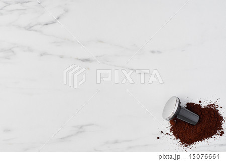 Coffee tamper and ground coffee on white marble Coffee tamper and ground coffee on white marble 45076664