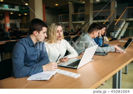 Group of college students studying in the school library, a girl and a boy are using a laptop and Group of college students studying in the school library, a girl and a boy are using a laptop and 45081004