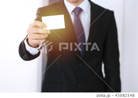 Businessman's hand holding business card with empty space, close-up Businessman's hand holding business card with empty space, close-up 45082548