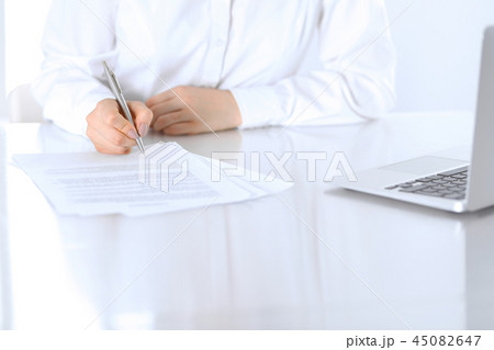 Close-up of female hands with pen over document,  business concept. Lawyer or business woman at wor 45082647