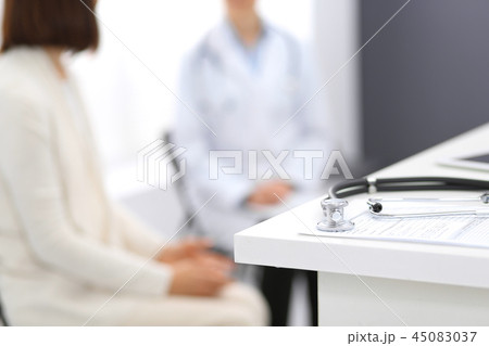 Stethoscope, clipboard with medical form lying on hospital reception desk with laptop computer and 45083037