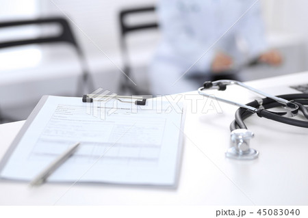Stethoscope, prescription medical form lying on hospital reception desk with laptop computer and 45083040