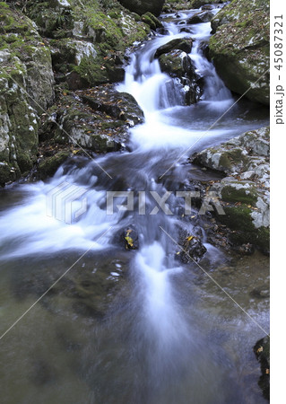 秋の渓谷　苔むした岩と水の流れ　 45087321