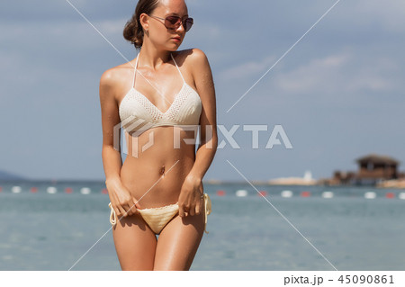 Woman untying swimwear panties 45090861