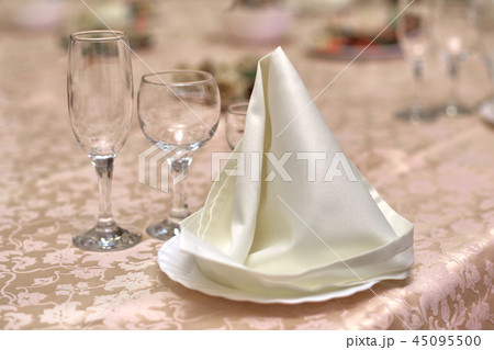 Festive table setting, folded napkin on a plate Festive table setting, folded napkin on a plate 45095500