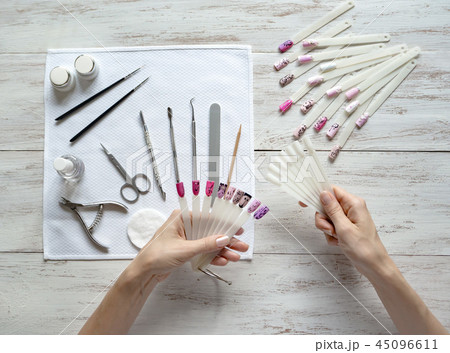 Nail art samples in female hands. Top view. Nail art samples in female hands. Top view. 45096611