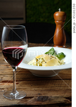 Glass of red wine, cheese pasta and pepper mill 45101350