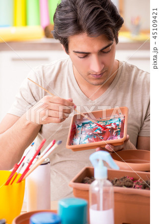 Young man decorating pottery in class 45109421