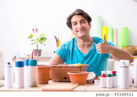 Young man decorating pottery in class 45109531