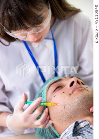 Plastic surgeon preparing for operation on man face Plastic surgeon preparing for operation on man face 45110840