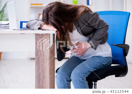 Pregnant woman struggling with pain in office 45112544