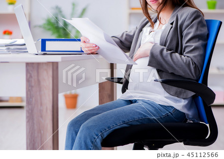 Pregnant woman struggling with pain in office Pregnant woman struggling with pain in office 45112566