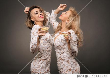 two beautiful young women with martini glasses 45112936
