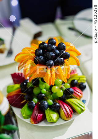 Fruit slicing on a plate, decorated table. 45120238