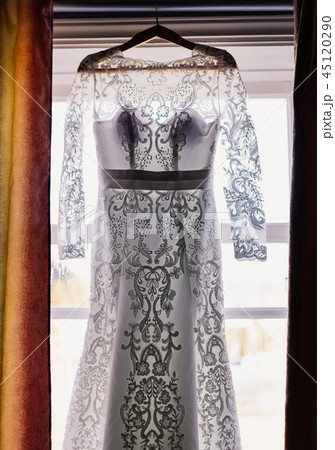 Wedding dress hanging on the window in the room Wedding dress hanging on the window in the room 45120290