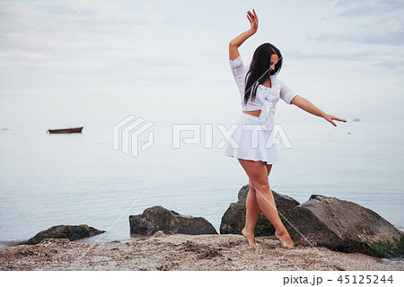 girl in frock dances barefoot on sand beach hands girl in frock dances barefoot on sand beach hands 45125244