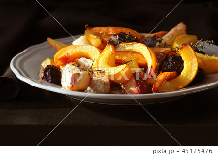 Grilled fall seasonal vegetables on plate over a dark background Grilled fall seasonal vegetables on plate over a dark background 45125476