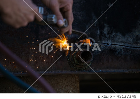 Worker cuts and brews black metal close-up shot Worker cuts and brews black metal close-up shot 45127349