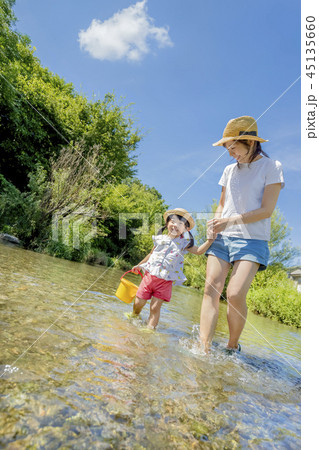 川で水遊びをする母と娘の写真素材