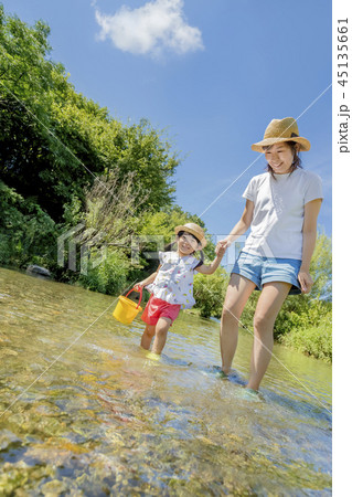 川で水遊びをする母と娘の写真素材