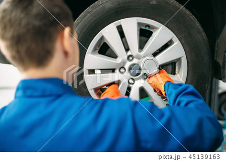 Mechanic unscrews the wheel, tire service 45139163