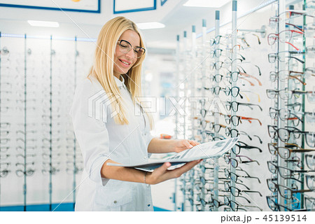 Female optician with glasses catalog in hands Female optician with glasses catalog in hands 45139514