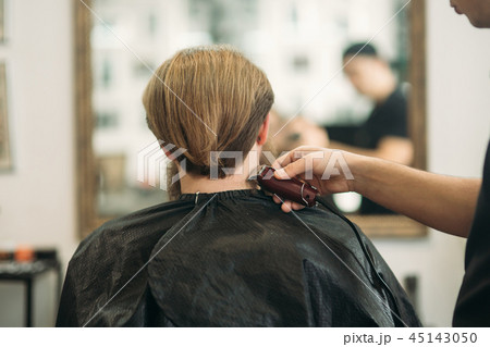 Bearded Man having a haircut with a hair clippers. Back view 45143050