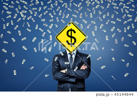 A businessman stands under a rainfall of dollar banknotes with a dollar road sign instead of his A businessman stands under a rainfall of dollar banknotes with a dollar road sign instead of his 45144644