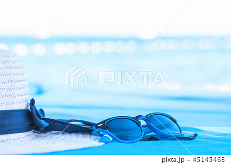 White summer hat with sunglasses at seaside White summer hat with sunglasses at seaside 45145463