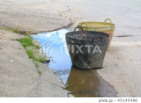 trash basket plastic black on road in the city 45145480