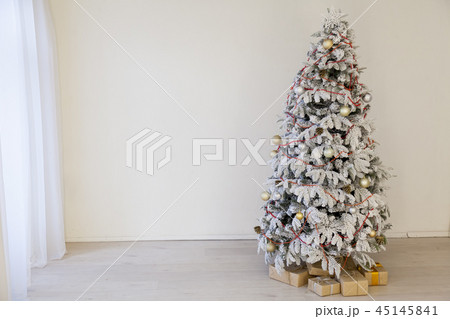 Christmas snowy Christmas tree with presents in a white room in winter 45145841