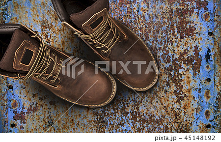 Men's brown boots on old rusty background Men's brown boots on old rusty background 45148192