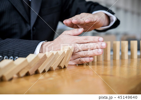 Wooden game strategy, Businessman hand stopping falling wooden d Wooden game strategy, Businessman hand stopping falling wooden d 45149640