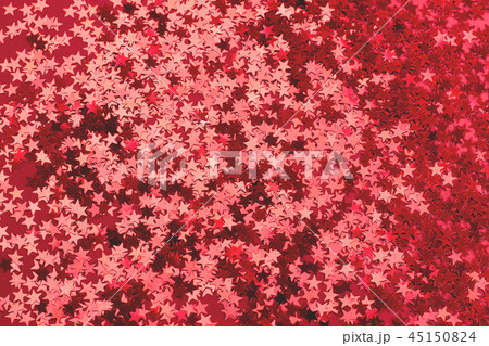 Metallic star shaped confetti on festive red background. Metallic star shaped confetti on festive red background. 45150824