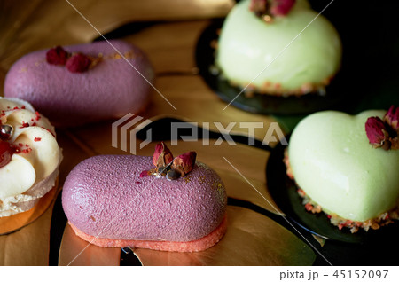 Moscovie cakes purple and lemon yellow. Pistachio and fruit. Culinary art.Gold leaf monstera 45152097